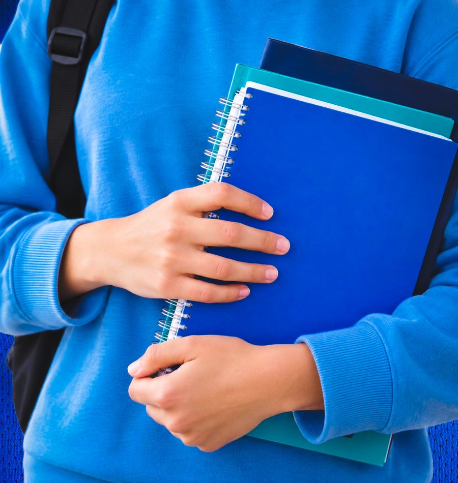 Student holding notebooks, ready to learn with AIOAK Academy